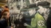 Посетители рассматривают экспонаты выставки "Кто был нацистом? Денацификация в Германии после 1945 года". Берлин, 2020 год