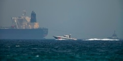 Катер Береговой охраны ОАЭ на фоне одного из супертанкеров. Оманский залив, вблизи побережья эмирата Фуджайра, 14 октября 2021 года