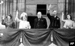 8 мая 1945 года, Британия празднует победу во Второй мировой войне. На балконе Букингемского дворца, слева направо: наследная принцесса Елизавета, королева-мать Елизавета, премьер-министр Уинстон Черчилль, король Георг VI, принцесса Маргарет (младшая дочь королевской четы)
