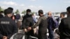 RUSSIA -- Uzbek migrant workers and security guard are seen before an Uzbekistan Airways evacuation flight to Tashkent, at Tolmachevo Airport near Novosibirsk, May 23, 2020