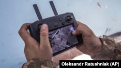 Украинский солдат наблюдает за перемещениями российских войск через экран пульта управления дрона в битве за Северодонецк