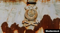 Герб Советского Союза на заржавевшем локомотиве, оставленном в зоне аварии на Чернобыльской АЭС в 1986 году