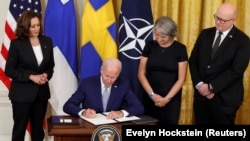 Президент США Джо Байден вместе с вице-президентом Камалой Харрис (слева), послом Швеции в США Карин Олофсдоттер и послом Финляндии в США Микко Хаутала подписывают документы, подтверждающие вступление Финляндии и Швеции в НАТО, 9 августа 2022 года