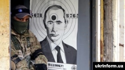 Боец Территориальной обороны Украины и мишень с изображением президента России Владимира Путина во время военной подготовки недалеко от Киева, 20 мая 2022 года 
