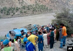 A bus lays in a ravine in northwest Pakistan on July 14 after a bus explosion killed 13 people, including nine Chinese workers at a nearby hydropower plant.