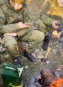 Российские солдаты смотрят в экраны своих смартфонов на привале, Ростовская область, февраль 2022 года, кадр из видео в тиктоке