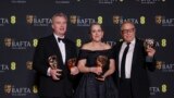 S lijeva, reditelj Christopher Nolan i producenti Emma Thomas i Charles Roven, dobitnici nagrade za najbolji film za 'Openheimer', poziraju za fotografije na 77. dodjeli filmskih nagrada Britanske akademije, u Londonu, 18. februara 2024. (Foto: Vianney Le Caer/Invision/AP)
