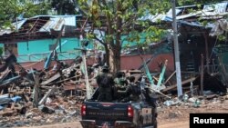 Soldiers from the Karen National Liberation Army (KNLA) patrol in Myawaddy, the Thailand-Myanmar border town under the control of a coalition of rebel forces led by the Karen National Union, in Myanmar, April 15, 2024.