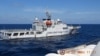 2024年2月8日，菲律賓南中國海的斯卡伯勒淺灘（中國稱黃岩島）附近，一艘中國海警船從菲律賓海警船“特雷莎·馬格巴努亞號”旁駛過。 （路透社照片）