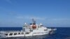 2024年2月8日，菲律賓南中國海斯卡伯勒淺灘附近，一艘中國海岸警衛隊船隻在菲律賓海岸警衛隊船隻特雷莎·馬格巴努亞號旁駛過。（路透社）