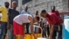 (FILE) Residents fill their containers with potable water in Port-au-Prince, Haiti, March 8, 2024. 