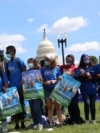 FILE - Demonstrators lock arms during a rally with migrant families and immigration advocates calling for a pathway towards citizenship, on Capitol Hill in Washington, Sept. 20, 2021. 
