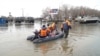 Rescuers ride a boat in a flooded street of Orsk, Russia, April 9, 2024, in this still image taken from video. 