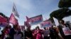 People hold banners reading 'We are families not crimes' during a pro-surrogacy flash-mob in Rome, April 5, 2024.