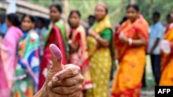 A woman shows her inked finger after casting her ballot to vote in the first part of India&#39;s general election at a voting center in Kalamati village, Dinhata district of Cooch Behar in the country&#39;s West Bengal state.