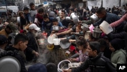 FILE - Palestinians line up for a meal in Rafah, Gaza Strip, Dec. 21, 2023. 