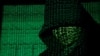 资料照片：二进制代码被投影到一个戴兜帽的男人身上。