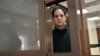 El periodista estadounidense Evan Gershkovich, arrestado por cargos de espionaje, mira desde el interior de una celda antes de una audiencia para una apelación sobre su detención preventiva prolongada, en el Tribunal de la Ciudad de Moscú en Moscú, el 20 de febrero de 2024.