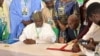 Nigeria's environment minister, Balarbe Abbas Lawal, seated at left, and his Cameroonian counterpart, Jules Doret Ndongo, are pictured at the signing of a transborder agreement to protect wildlife, in Abuja, Nigeria, April 19, 2024. (Timothy Obiezu/VOA)