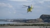 A helicopter of the Emergency medical services takes off from the Wimereux dike on April 23, 2024, after the recovery of the body of five migrants, who died overnight trying to cross the Channel from France to Britain on their overcrowded small boat. 