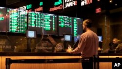 FILE - A customer makes a sports bet at the Borgata casino in Atlantic City N.J. on March 17, 2022 just before the March Madness NCAA college basketball tournament began. 