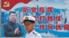 资料照：一名中国解放军海军士兵在香港的海军基地站在有着中国领导人习近平画像的宣传标语前。（2016年7月8日）
