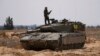 An Israeli tank maneuvers, amid the ongoing conflict between Israel and the Palestinian Islamist group Hamas, near the Israel-Gaza Border, in southern Israel, May 7, 2024. 