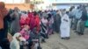 (FILE) People displaced by the ongoing conflict in Sudan between the army and paramilitaries wait to receive aid from a charity in Sudan.