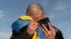 资料照片： 2024年1月31日，一名乌克兰战俘在乌克兰-俄罗斯边境交换战俘后打电话给亲戚时哭泣。（美联社照片）
