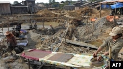 A photo taken on January 13, 2011, shows a Cambodian man (R) working at O'Clor village in Mondulkiri province, some 550 kilometers northeast of Phnom Penh.