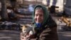 Una mujer sonríe mientras sostiene un gato en la ciudad de Siversk, en medio del ataque de Rusia a Ucrania, en la región de Donetsk, Ucrania, el 20 de febrero de 2023.&nbsp;