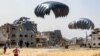 People rush to landing humanitarian aid packages dropped over the northern Gaza Strip on April 23, 2024.