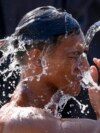 A man douses himself with water along a street as hot temperatures continue in Manila, Philippines, April 26, 2024.