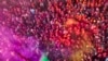 Villagers from Barsana and Nandgaon smeared with colors play Lathmar Holi at Nandagram temple in Nandgoan village, 115 kilometers (70 miles) south of New Delhi, India, March 19, 2024.
