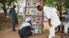 FILE - Men look at news headlines of various newspapers in Bamako on June 11, 2021.