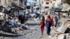 巴勒斯坦人走过被以色列军队炸毁的建筑废墟。(2024年3月20日)
