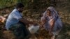 FILE - Meerabi Chunduru, right, an avid practitioner and advocate of natural farming techniques, is assisted by Bhaskar Rao as they prepare a natural dry pesticide at her farm in Aremanda village, India, Feb. 11, 2024. 