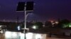 Des personnes sont assises sous des lampadaires utilisant des panneaux solaires dans un quartier d'Agadez, dans le nord du Niger, le 5 avril 2017. (Photo ISSOUF SANOGO / AFP)