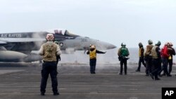 美日韩三国在东中国海举行联合海军军演，一架 F-18E 战斗机正准备从美国海军西奥多·罗斯福号航空母舰上起飞。(2024年4月11日)