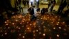 People light candles during a vigil for three police officer in front of Chile's police headquarters in Santiago, Chile, Saturday, April 27, 2024.