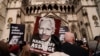 Manifestan kenbe pannkat apre Stella Assange, madanm fondate Wikileaks Julian Assange pibliye yon deklarasyon devan Kou Wayal Jistis la nan Lond, 26 Mas, 2024.