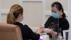 FILE - A nail technician gives a manicure to a customer at KB Nails in Sacramento, California, on Jan. 25, 2021. 