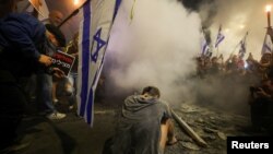 A demonstrator sits during a protest in Tel Aviv, Israel, against Israeli Prime Minister Benjamin Netanyahu's government and call for the release of hostages kidnapped in Hamas' deadly October 7 attack on Israel, March 30, 2024