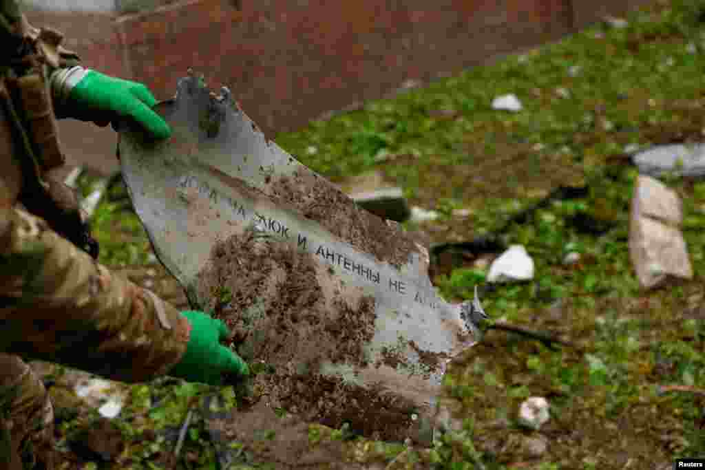 Un experto de la policía muestra parte de un misil ruso en el sitio de un edificio destruido en Chernihiv, Ucrania, el 17 de abril de 2024. Tres explosiones sacudieron una concurrida zona central de la ciudad poco después de las 9 a.m. hora local (0600 GMT), dijeron funcionarios. REUTERS/Valentyn Ogirenko