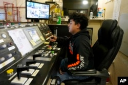 FILE - A worker sits in a mining winch operations room at Energy Fuels' Pinyon Plain Mine, Jan. 31, 2024, near Tusayan, Arizona.