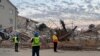 Funcionários são vistos no local do desabamento de um edifício em George, a leste da Cidade do Cabo, a 7 de maio de 2024.