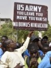 FILE - Protesters react as a man holds up a sign demanding U.S. Army soldiers leave Niger without negotiation during a demonstration in Niamey, on April 13, 2024. The U.S. will withdraw its troops from Niger, a source familiar with the matter said on Friday.