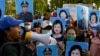 FILE - Protesters hold placards of Cambodia's Prime Minister Hun Sen and his wife Bun Rany as they call for benefits to help workers after their textile factory was shuttered related to the COVID-19 coronavirus pandemic in Phnom Penh on July 29, 2020.