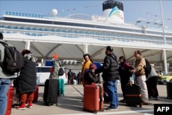 2024年1月1 日，乘客們在上海碼頭排隊等候登上中國第一艘國產郵輪愛達·魔都號。（法新社）