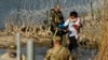 FILE - Migrants are taken into custody by officials at the Texas-Mexico border, in Eagle Pass, Texas, Jan. 3, 2024.